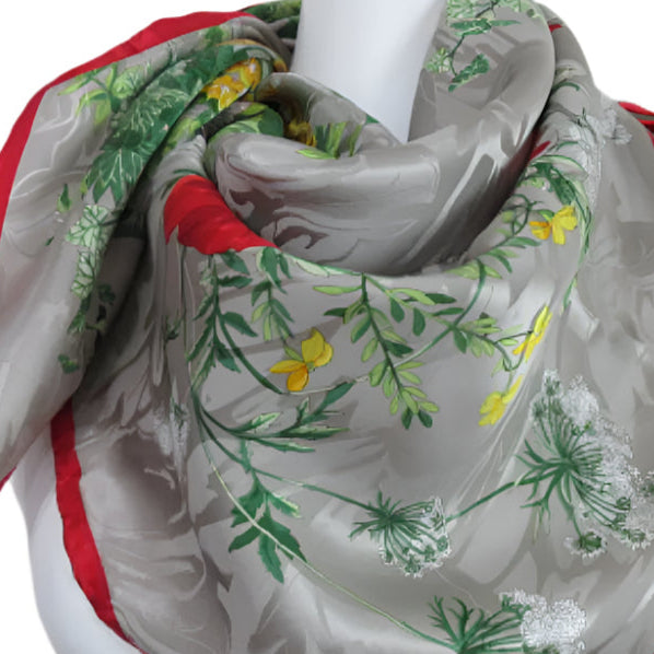 Erre floral patterned scarf with red border on a mannequin against a plain background