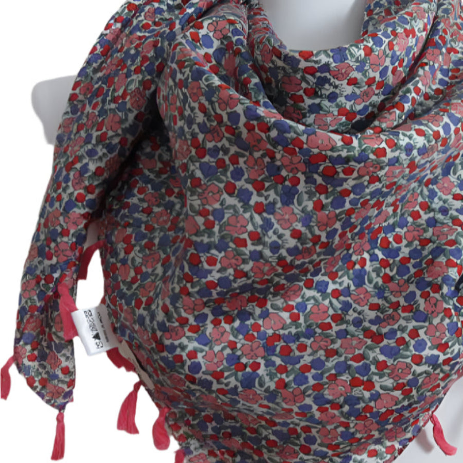 Floral patterned scarf with tassels on a mannequin against a white background