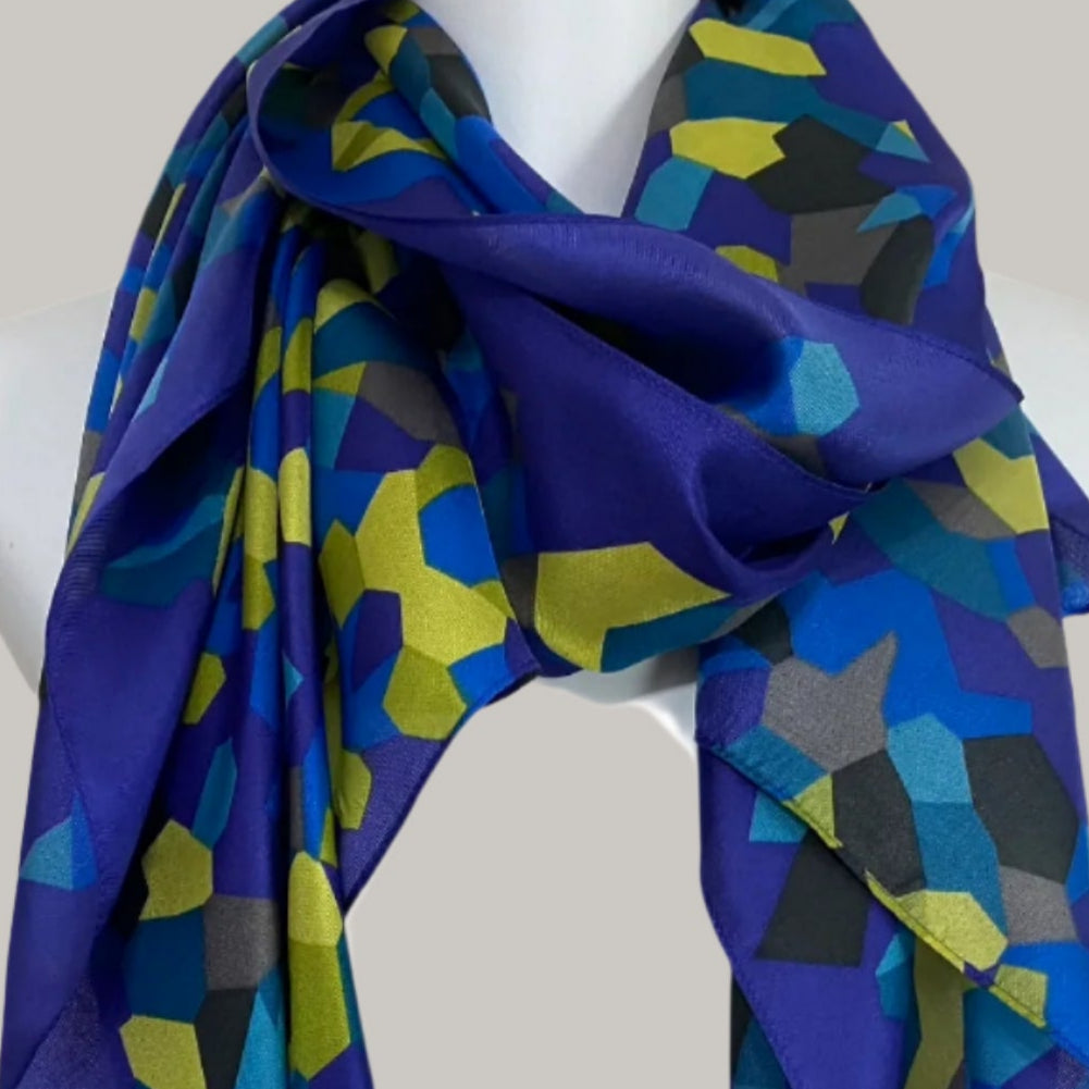 Colorful geometric patterned scarf on a mannequin against a beige background