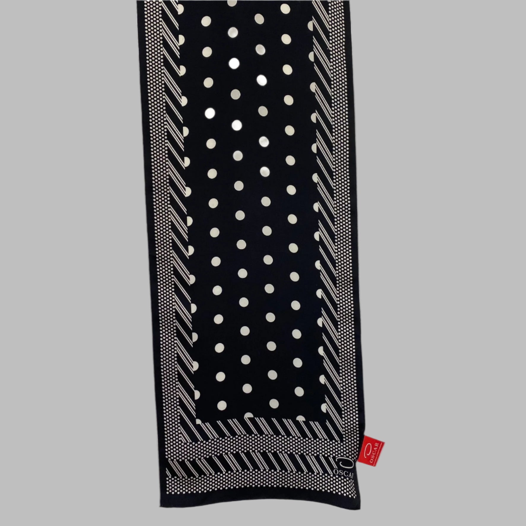 Black scarf with white polka dot pattern on a light gray background