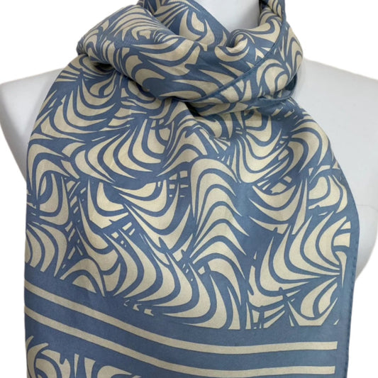 Blue and beige patterned scarf on a mannequin with a plain background