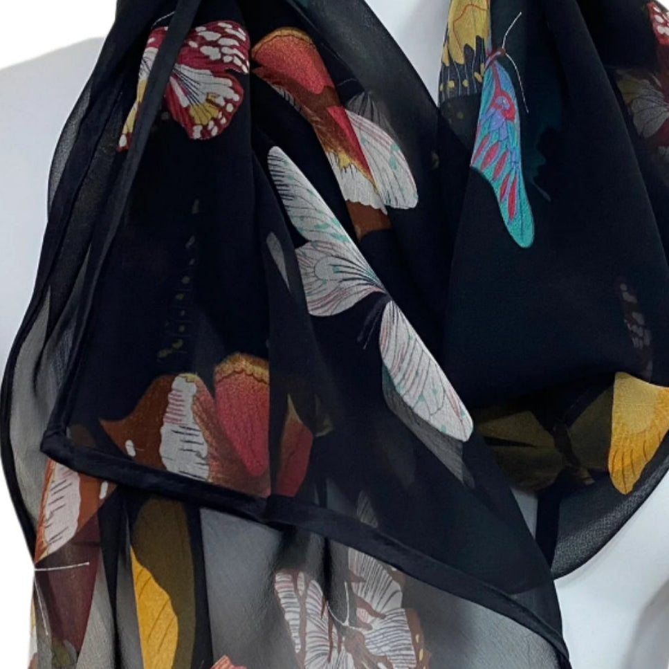 Black scarf with butterfly pattern on a mannequin against a white background