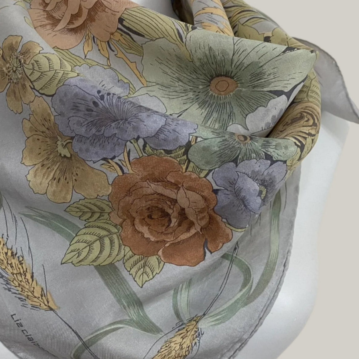 Floral patterned scarf on a mannequin with a neutral background
