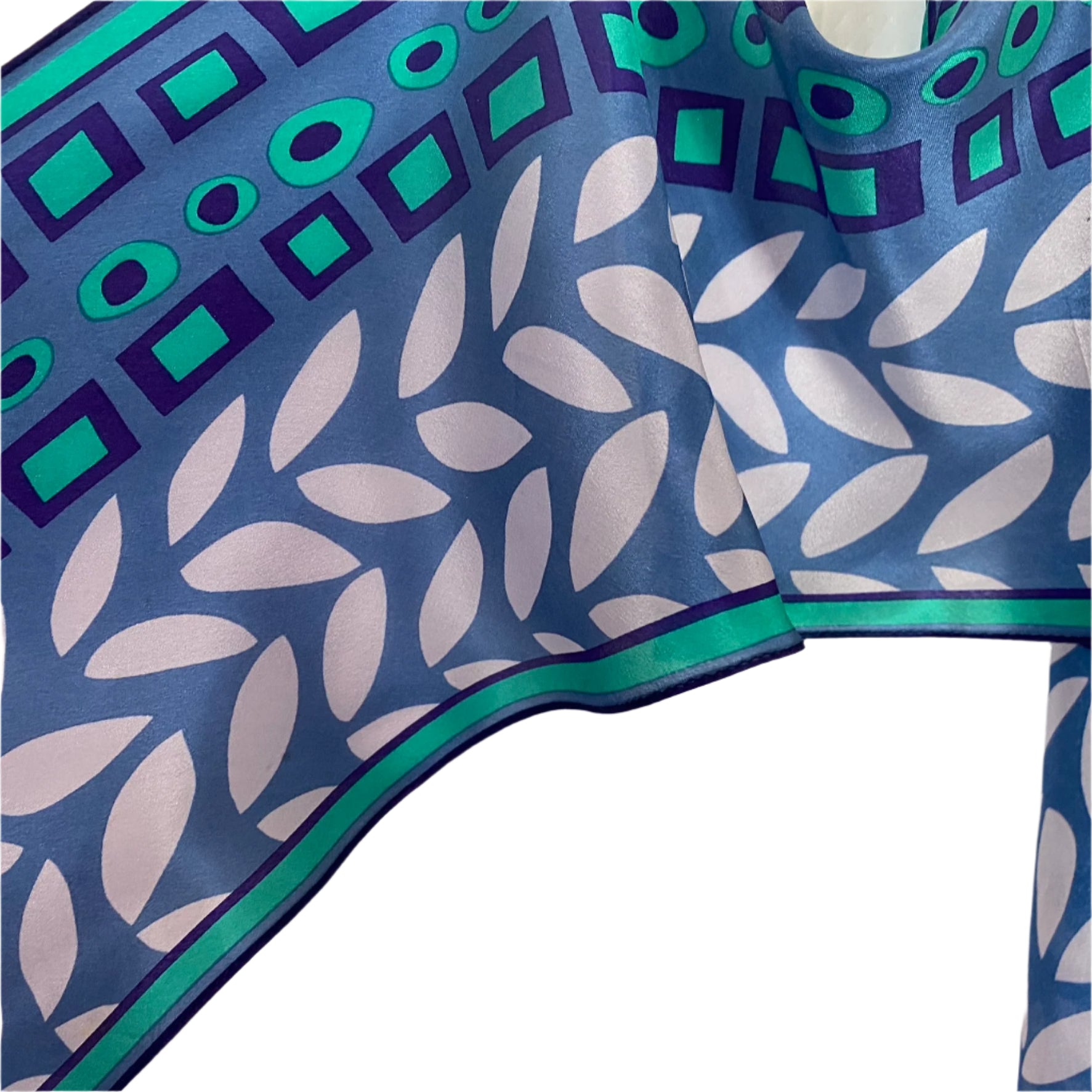 Anne Klein, Close-up of a blue fabric with white leaf pattern on a white background